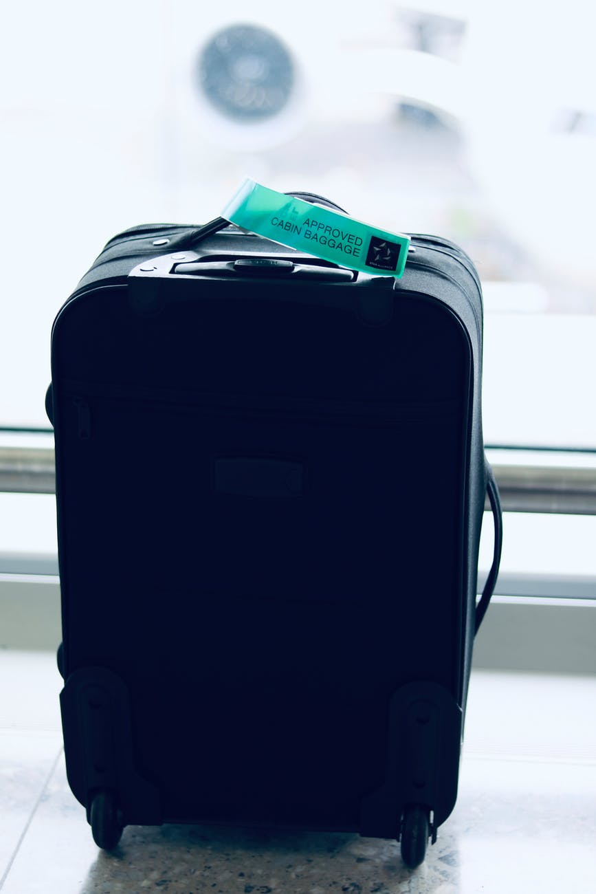 black luggage bag near wall